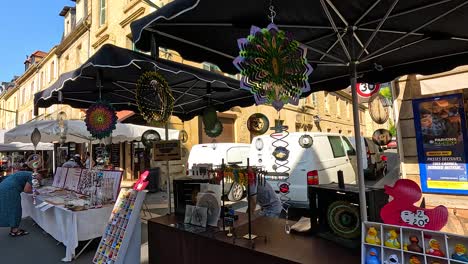 market stall displaying colorful wind spinners in sarlat, france