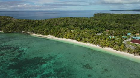 vista aérea de casas, bosques y una playa, en la isla lifou - pan, tiro de drones