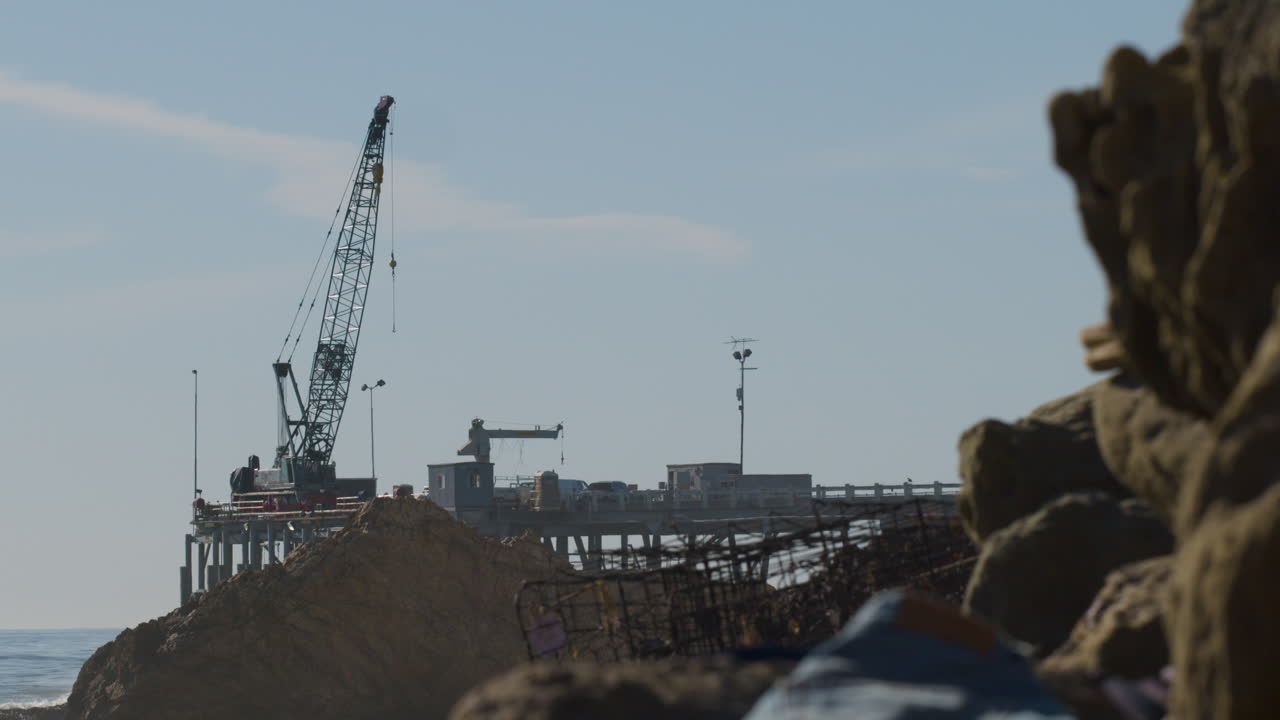 grúa de plataforma petrolera en el muelle con trampa para langostas en la playa de acantilado rocoso en cámara lenta 4k 60fps