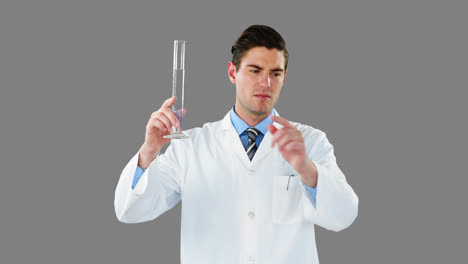 médico usando una pantalla digital mientras examina un químico en un tubo de ensayo
