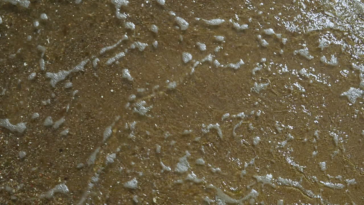 느린 동작, 바다 해안의 전망, 해안의 모래, 모래, 물에 쏟아지는 물의 거품