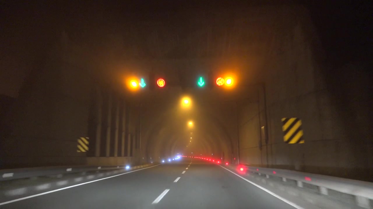Guidare attraverso un tunnel autostradale nebbioso di notte