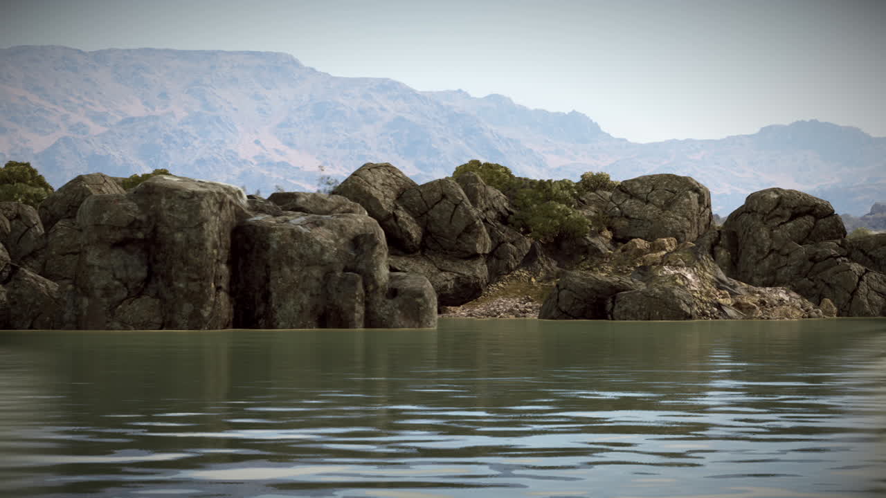 Calm waters reflect mountains and rocks under a clear sky at dawn