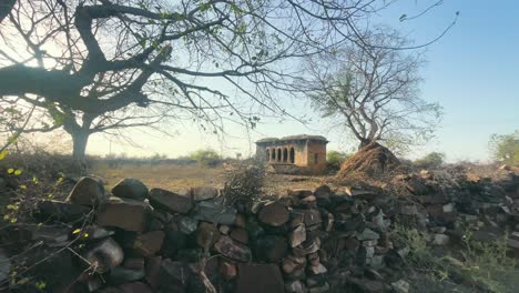 Weite-Aufnahme-Eines-Alten-Verlassenen-Gebäudes-Mit-Blattlosen-Bäumen-In-Einer-Halbtrockenen-Landschaft-Von-Madhya-Pradesh,-Indien