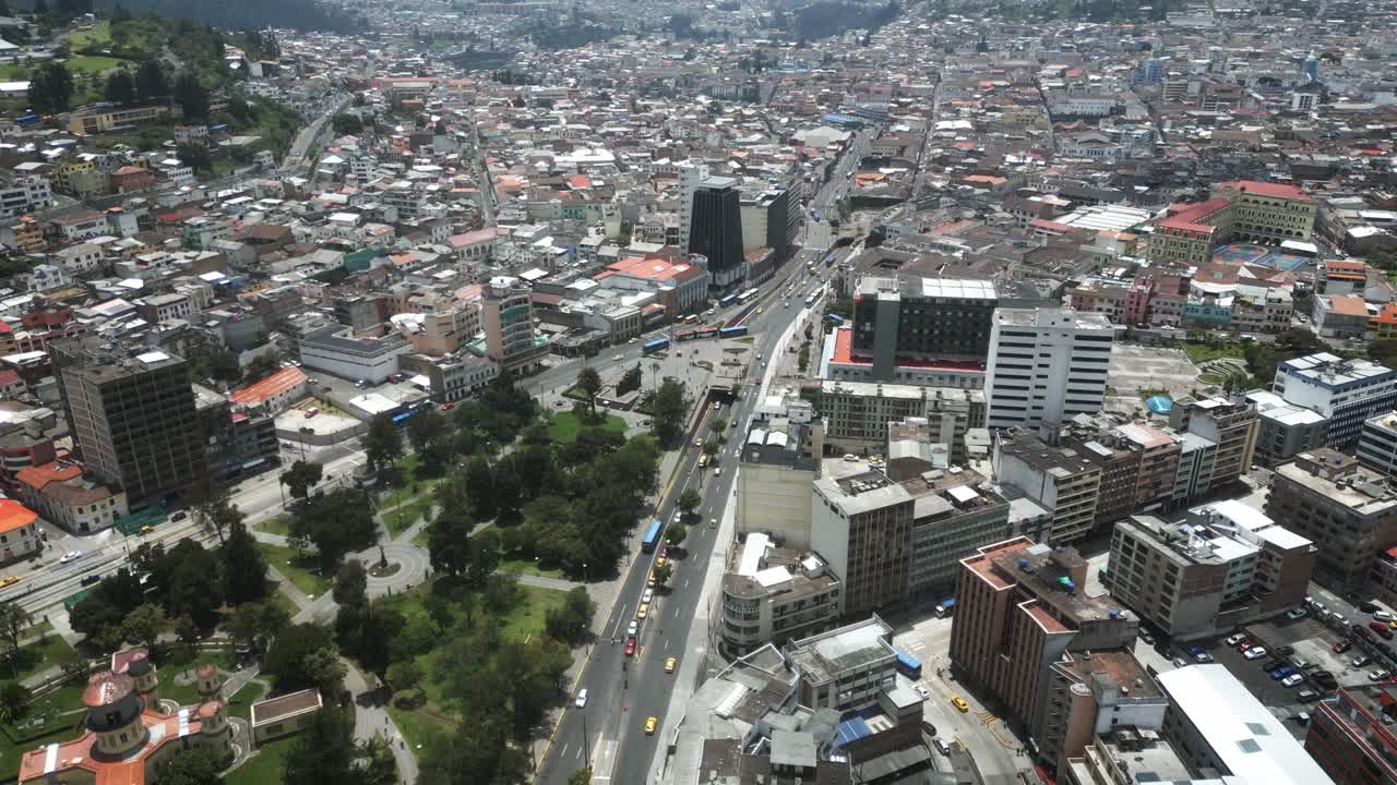 calma el tráfico de la ciudad cerca del parque en ecuador, avance aéreo