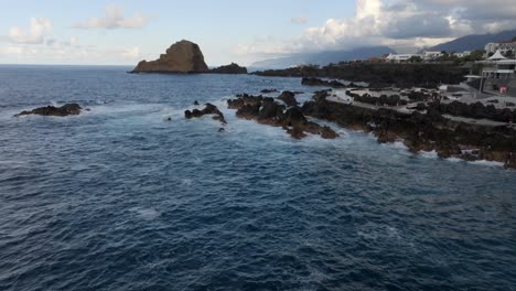 volcanic-pools-of-Porto-Moniz-in-Madeira-Portugal-footage-with-drones-of-cliffs,-ocean,-natural-bathing-spots,-and-houses-filmed-at-sunset