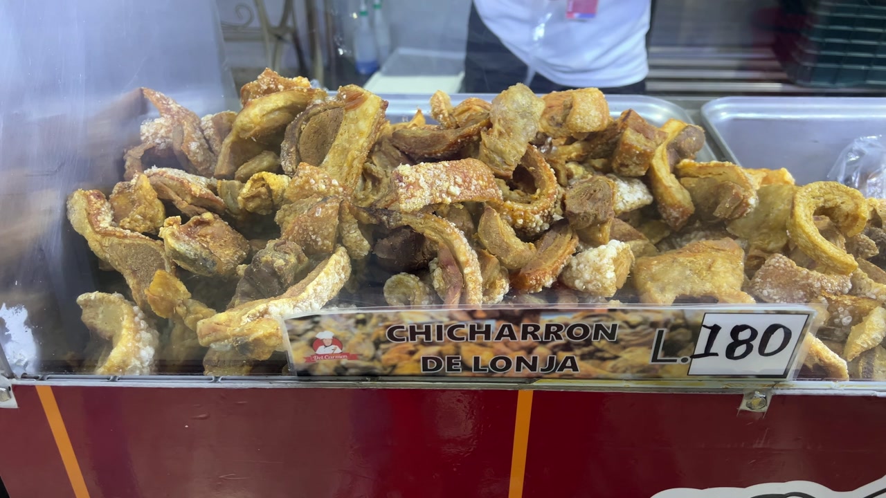 Honduras street food chicharrones displayed at a local market, showing crispy fried pork pieces prepared fresh as a traditional and popular local food.