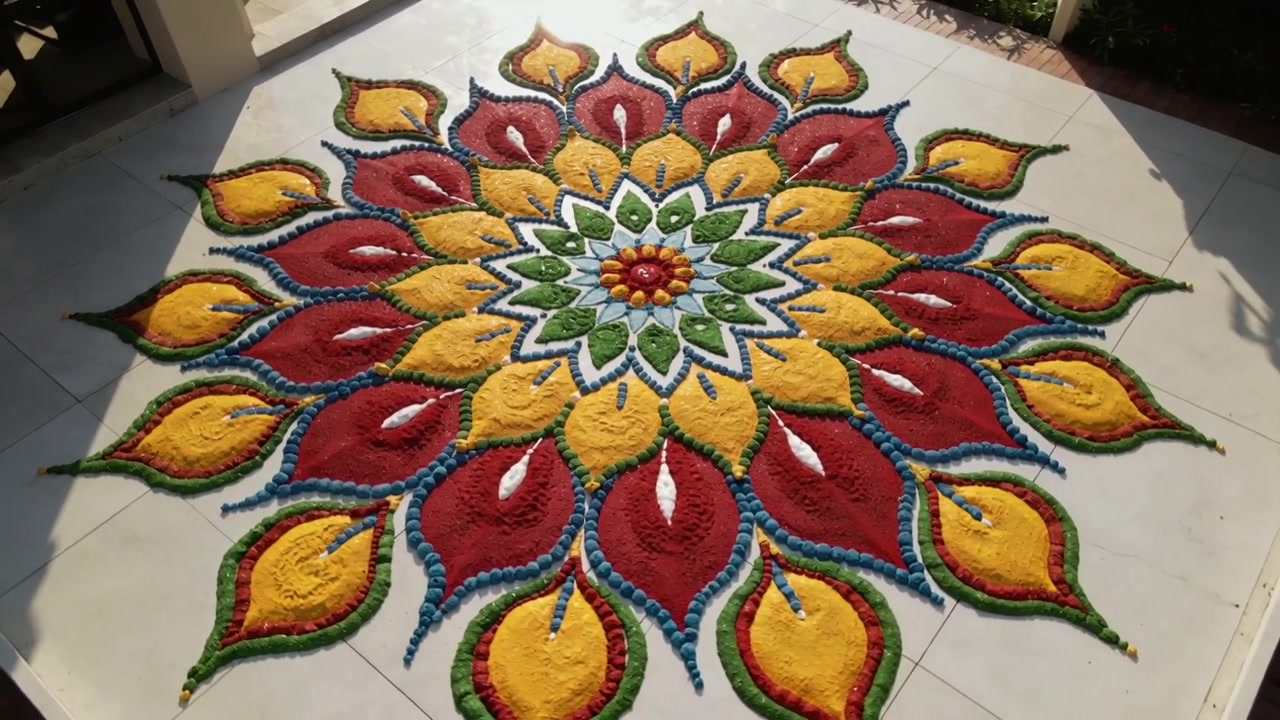 La telecamera si sposta e si centra, rivelando un mandala rangoli sul portico con polvere e ombre sul pavimento piastrellato.