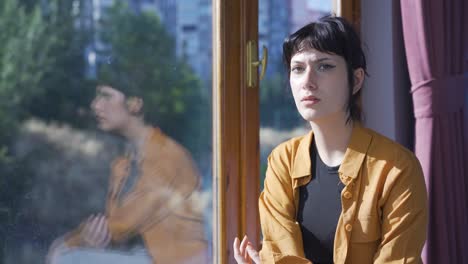 Unwell-young-woman-watches-out-the-window-to-relax.