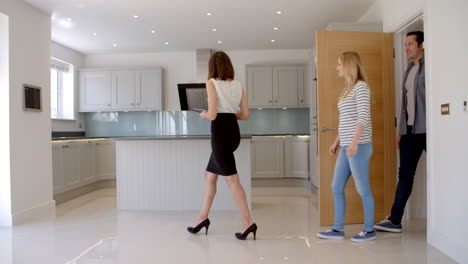 realtor showing couple around property for sale