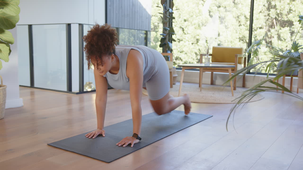 Exercising on yoga mat, plus size woman doing plank in modern living room