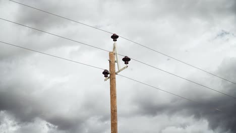 wooden telephone pole and cables with dark gloomy sky in the background