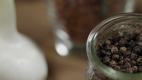 vista de cerca de la especia de pimienta negra entera en frasco, ingrediente para el chimichurri
