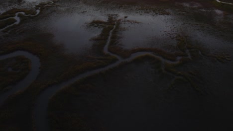 High-angle-aerial-dolly-along-swamp-wetlands-with-meandering-river-in-Chincoteague-Island-Virginia,-slow-motion