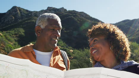 Una-Pareja-Afroamericana-De-Alto-Rango-Mirando-El-Mapa-Mientras-Caminan-Juntos-Por-Un-Sendero-En-El-Campo