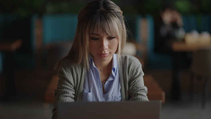 An Asian business woman writes the program code of the loya of her online store. Remote work.