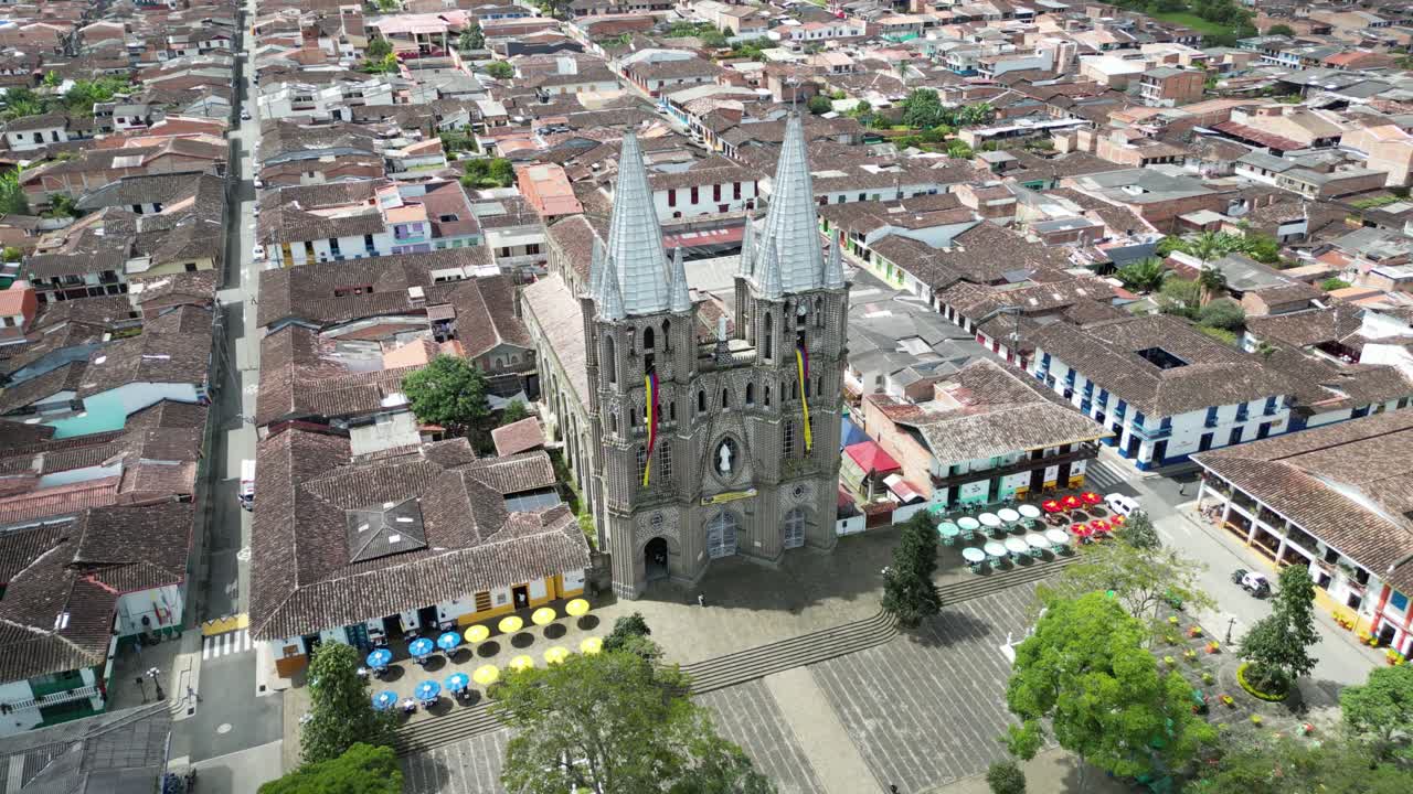 Aerial drone footage of the picturesque church Basílica Menor de la Inmaculada Concepción and the central square in the charming Andean town of Jardín in Colombia