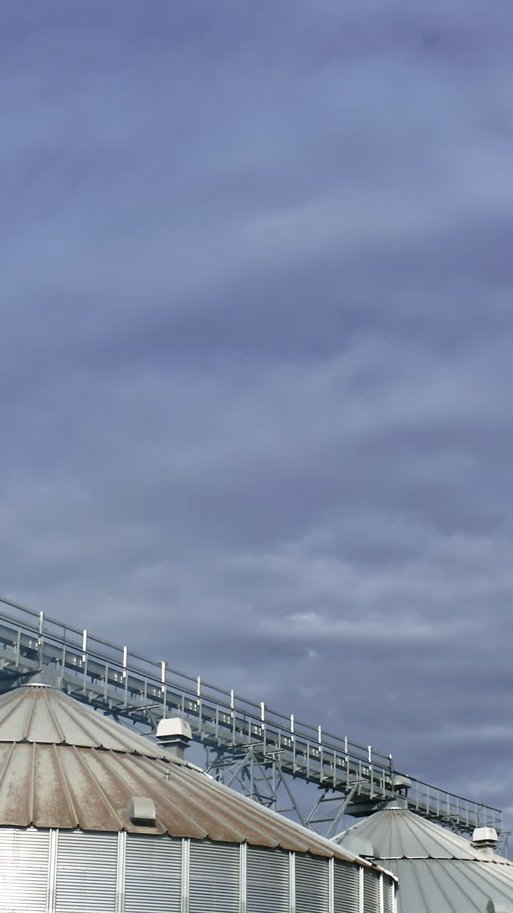 Elevator tanks factory aerial view. Grain farming harvesting silos. Vertical video
