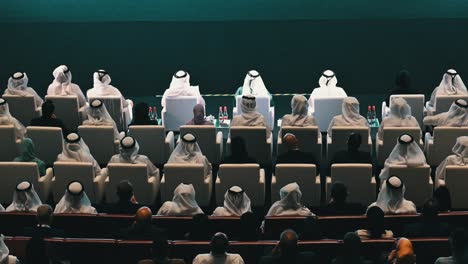 large group of people in traditional clothing at a conference