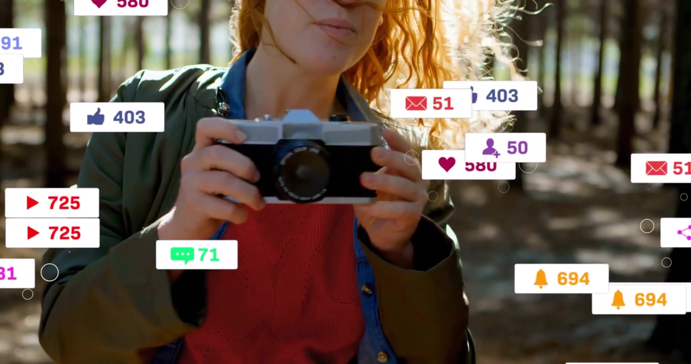 Rozetler çoğalırken, kadın güneşli çam ağaçları arasında eski bir fotoğraf makinesini kaldırarak sosyal medya için bir kare oluşturuyor.