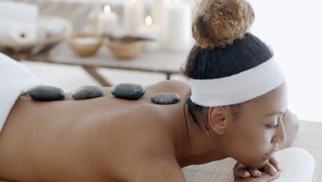 woman getting hot stones massage at spa