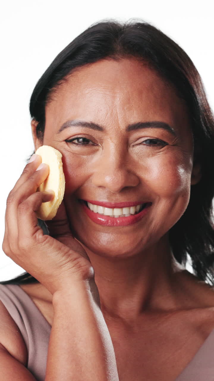 Smiling Mature Woman Using Facial Sponges for Skincare