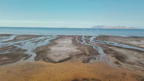 Watery-horizon-with-birds-flying-over-Great-Salt-Lake-shoreline