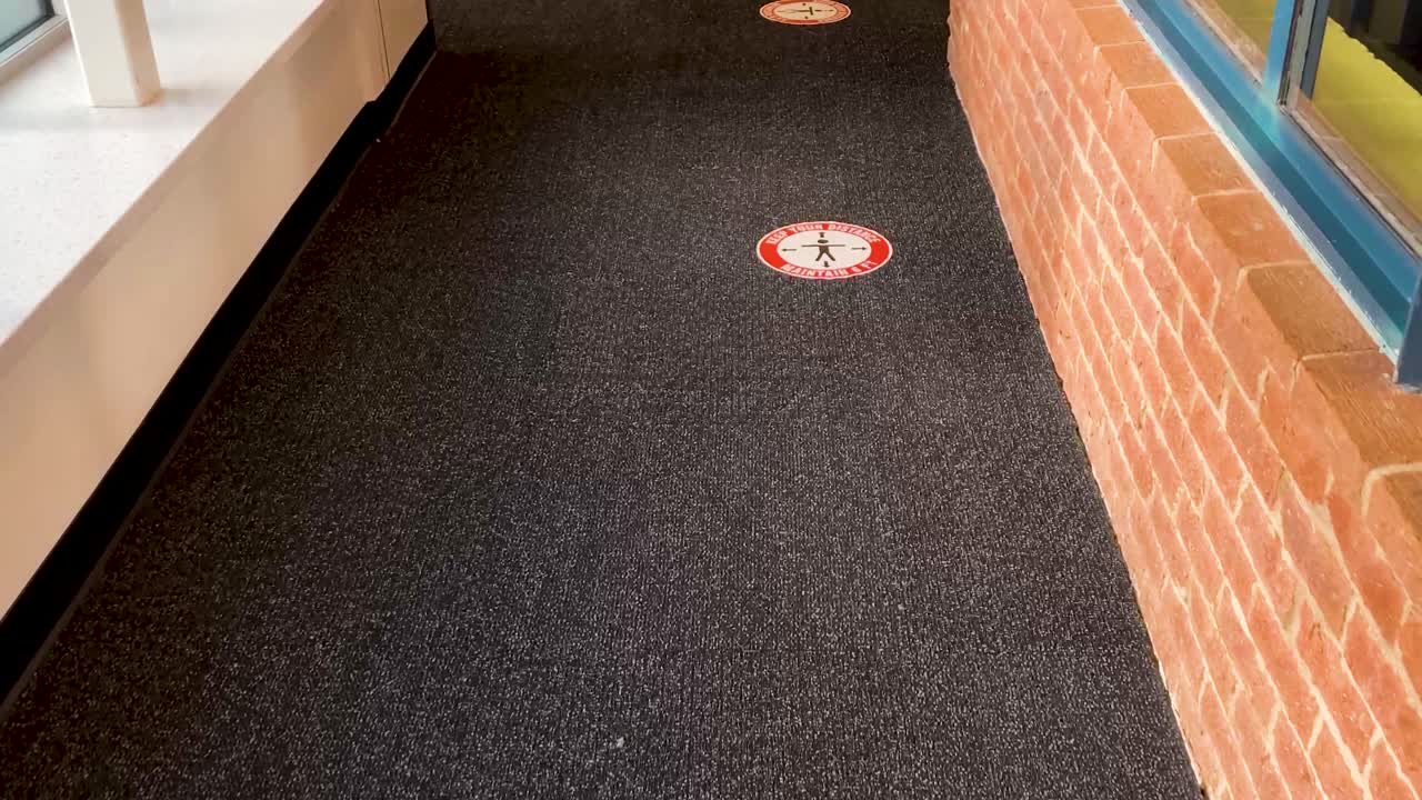 pegatinas de covid espaciadas en un piso de alfombra, estas son para ayudar a las personas a saber cómo distanciarse socialmente en la fila