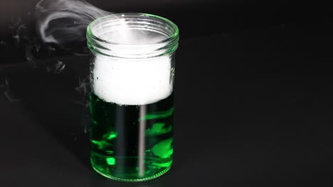 green liquid reacts, producing smoke and bubbles