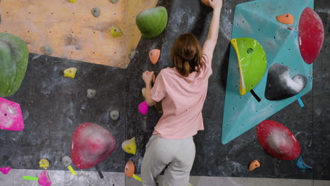 teenage boy bouldering indoors