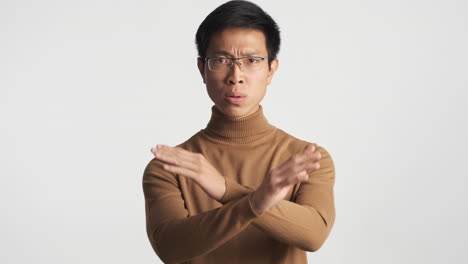 serious asian man showing no gesture.