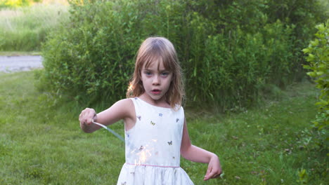 Little-girl-playing-with-a-sparkler-on-a-summer-evening