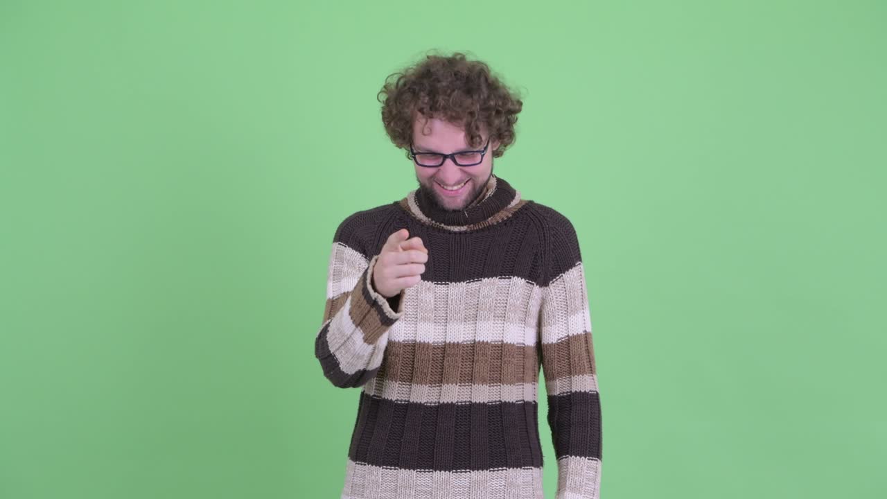 un joven guapo con barba y cabello rizado.
