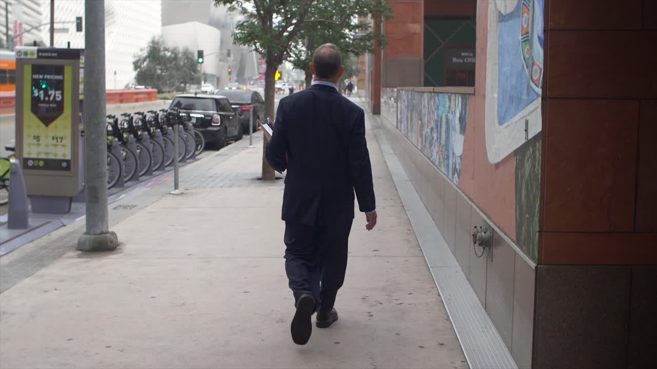 Businessman Walking On Pavement
