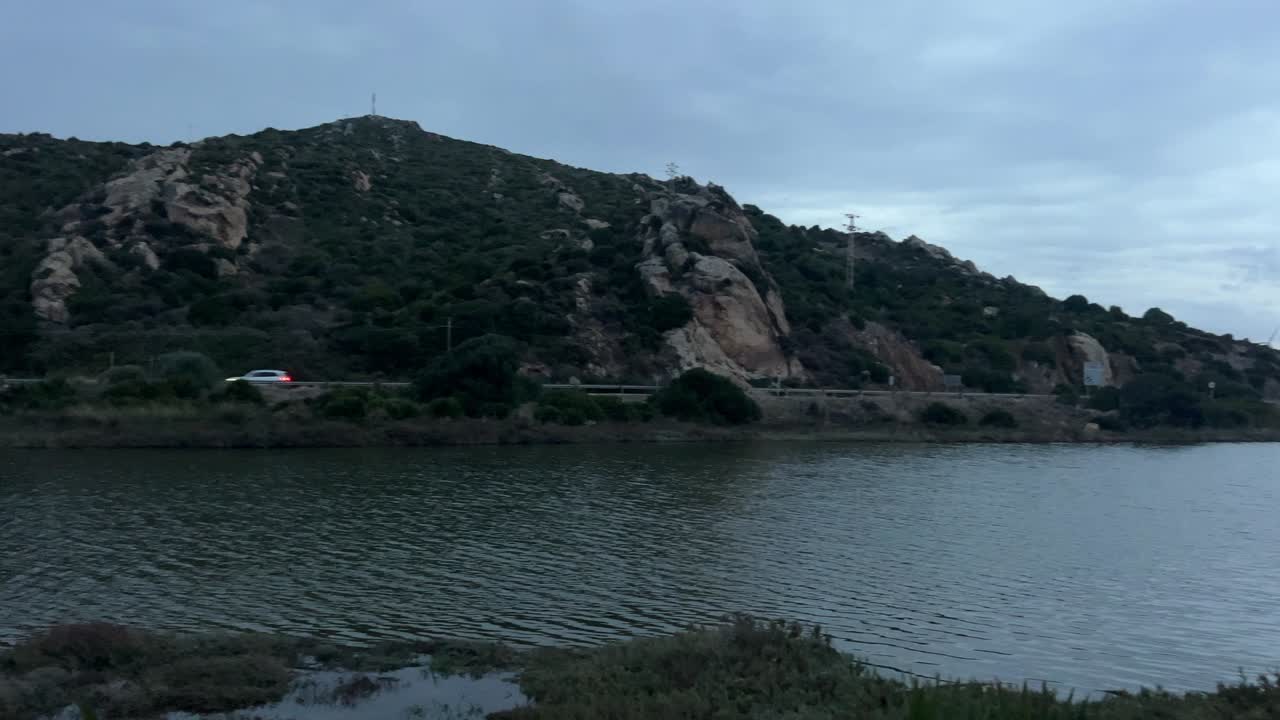 Panning View of Water Channel with Beach and Highway