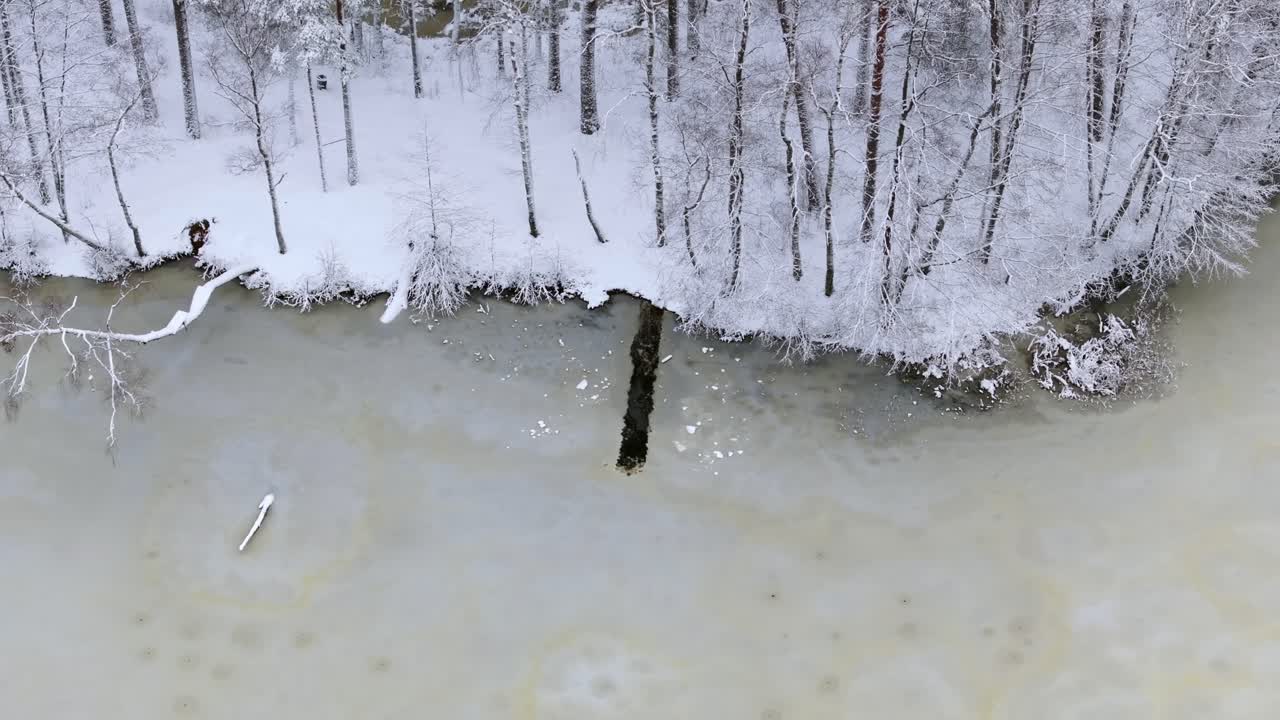 Long ice hole cut in frozen forest lake in Northern Europe, cold water swimmers