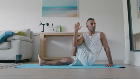 yoga de giro espinal por un hombre de 40 años con apariencia de oriente medio en su sala de estar