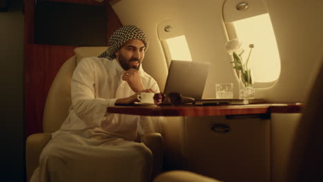 smiling businessman typing keyboard on aircraft. cheerful man chatting online