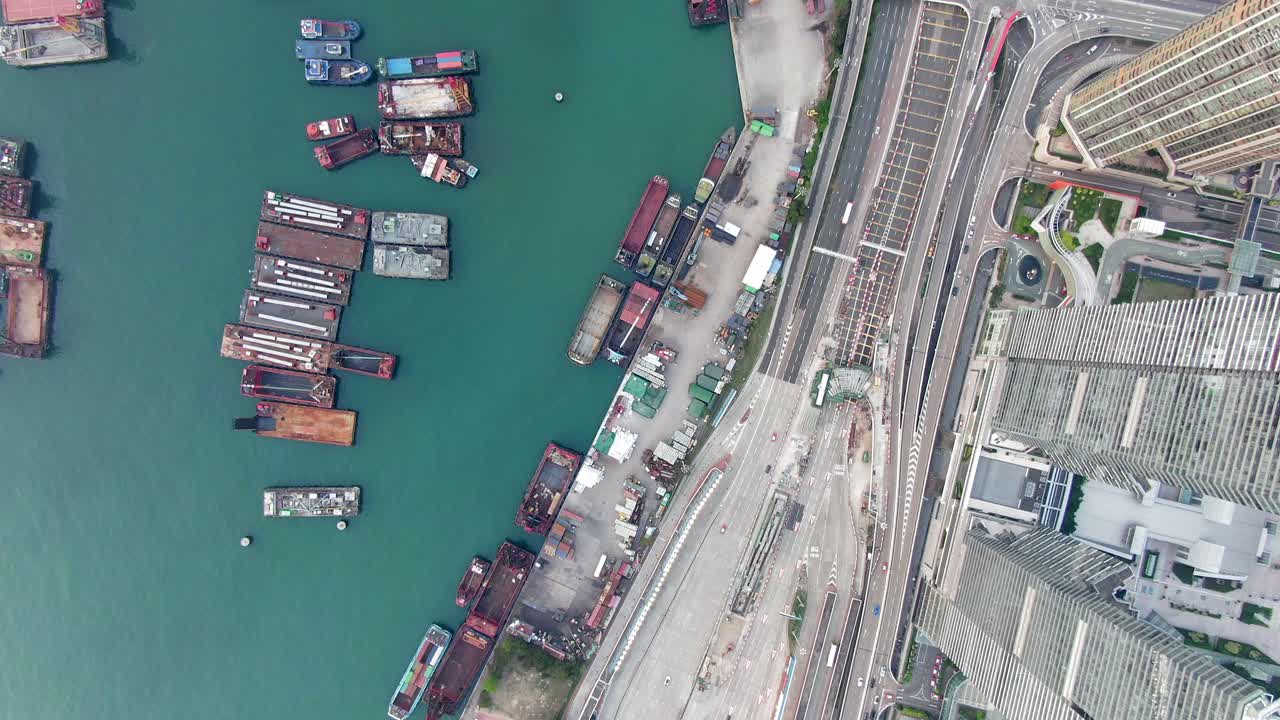 bahía de hong kong, vista aérea de arriba hacia abajo que muestra rascacielos, tráfico urbano y pequeños barcos