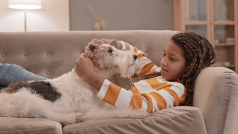 girl and dog lounging on couch