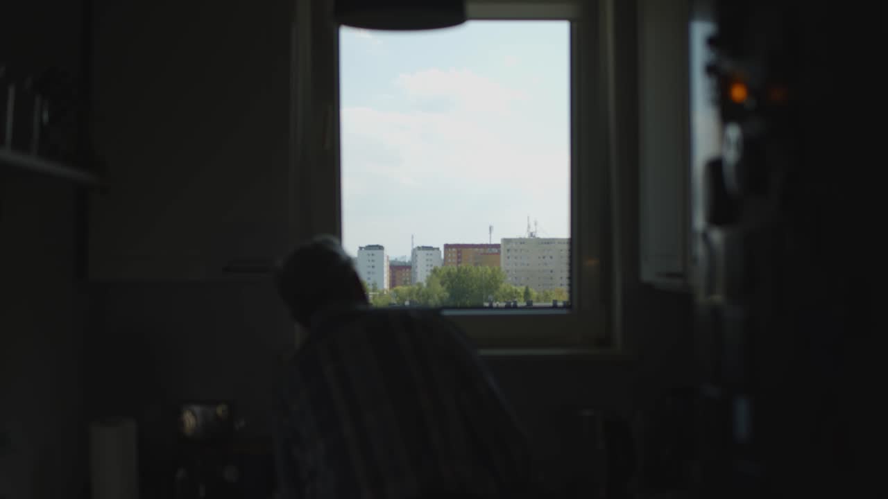 Man looking out of the windows to block of flats dark kitchen 4K