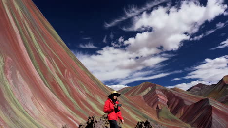 woman photographing vibrant rainbow mountains