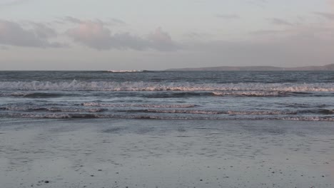 Early-morning-sandy-beach-with-tidal-waves-coming-in