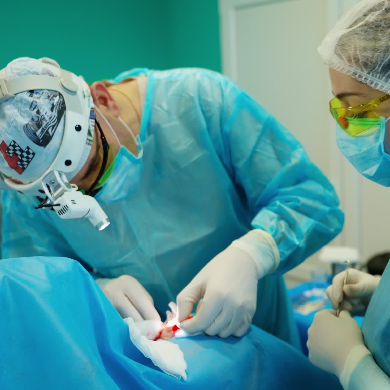 Doctor and nurse doing plastic surgery. Medical specialists in uniform with masks perform a surgery in the operating room.