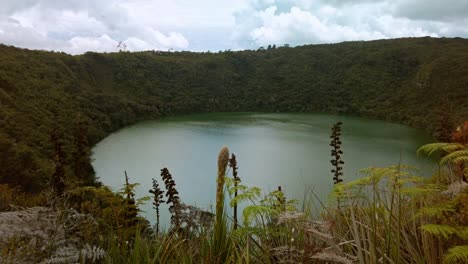 panoramic view panning to the right of the guatavita lagoon, where the legend of el dorado began, a tourist site in colombia on a cloudy day