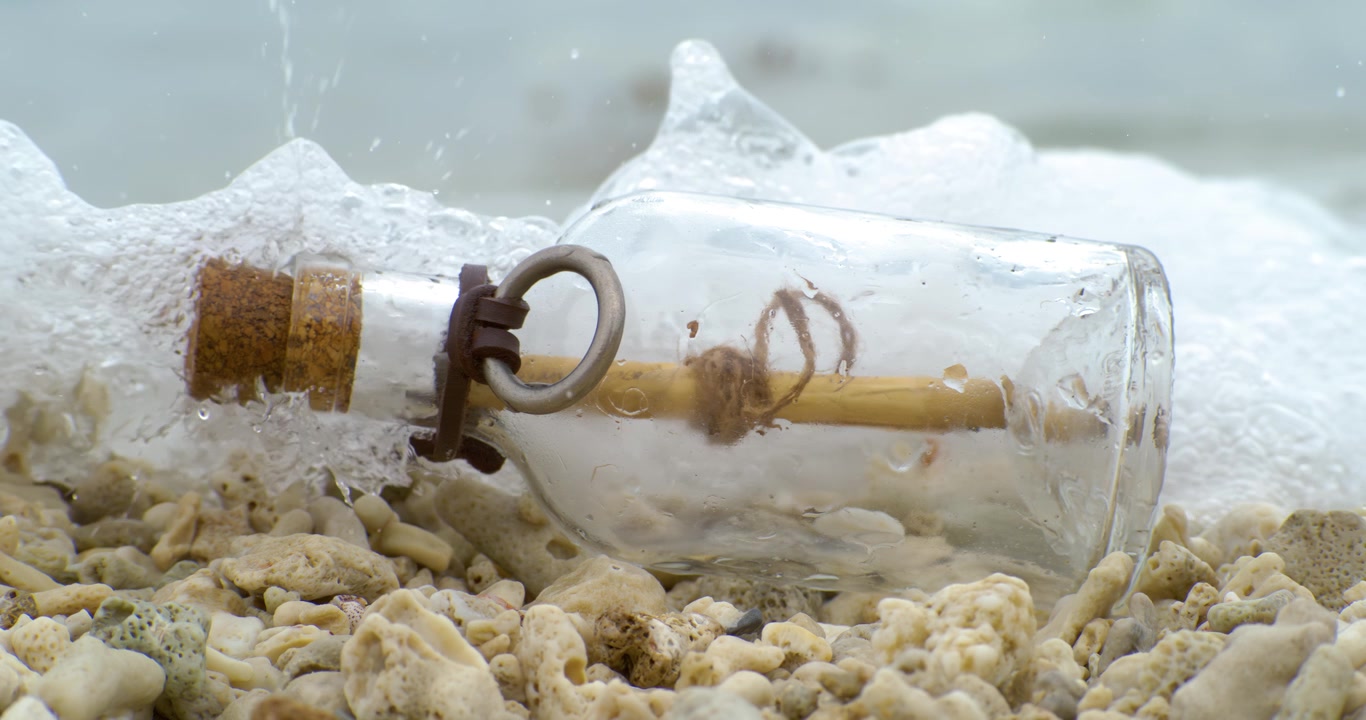 Messaggio nella bottiglia su una spiaggia di sabbia. Ripreso con una fotocamera super slow motion a 1000 fps