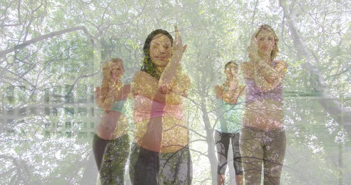Gruppe tritt auf Yogamatten auf Holzboden und führt Adlerarme für einen Fitness-Balance-Flow aus.