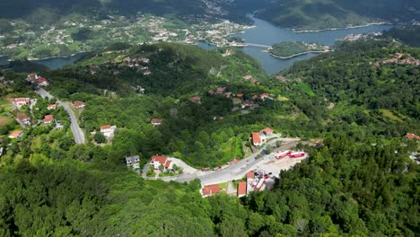aerial perspective of hillside residences in gerês national park, portugal, with caniçada dam against a sunny sky, parque nacional peneda-gerês