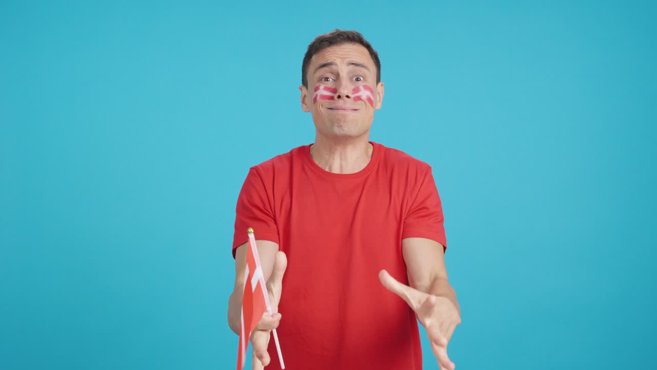 Man cheering for Denmark during a match that is lost