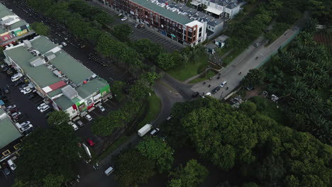 Vista-Aérea-De-Los-Vehículos-Que-Pasan-Por-Las-Calles-De-La-Zona-Suburbana-De-Yakarta,-Indonesia---Disparo-De-Drones